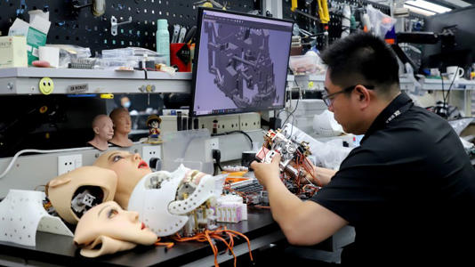 A technician works on the bionic humanoid robots at a workshop of Ex-Robots factory on June 23, 2025 in Dalian, Liaoning province. - VCG/Getty Images