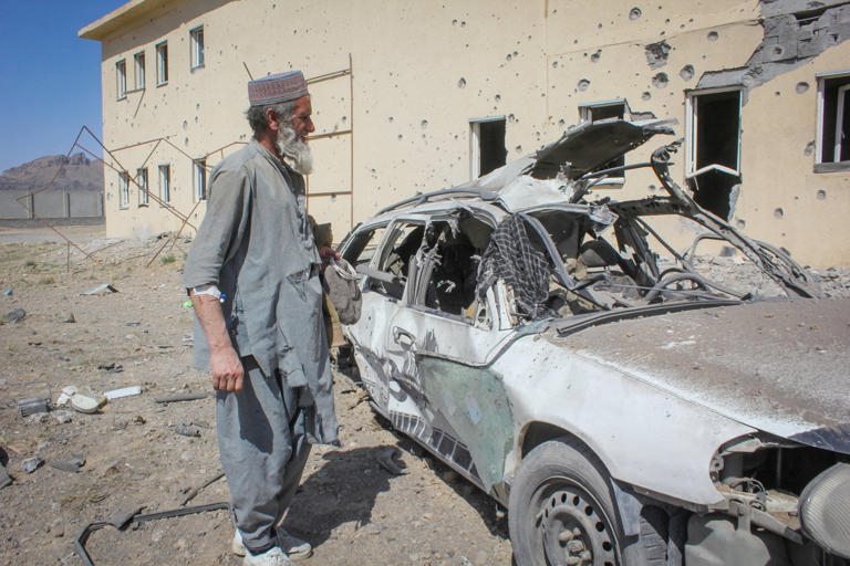 An Afghan man stands next to a damaged car in Kandahar on Saturday following airstrikes, amid the conflict between Afghanistan and Pakistan. Photo: Reuters