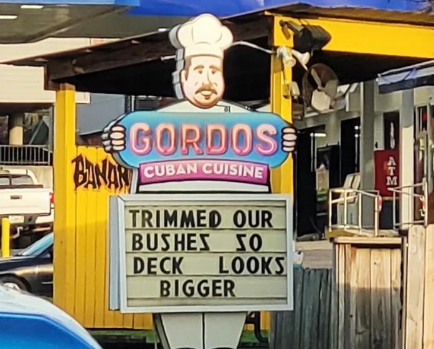Restaurant sign with chef mascot: "Trimmed our bushes so deck looks bigger."