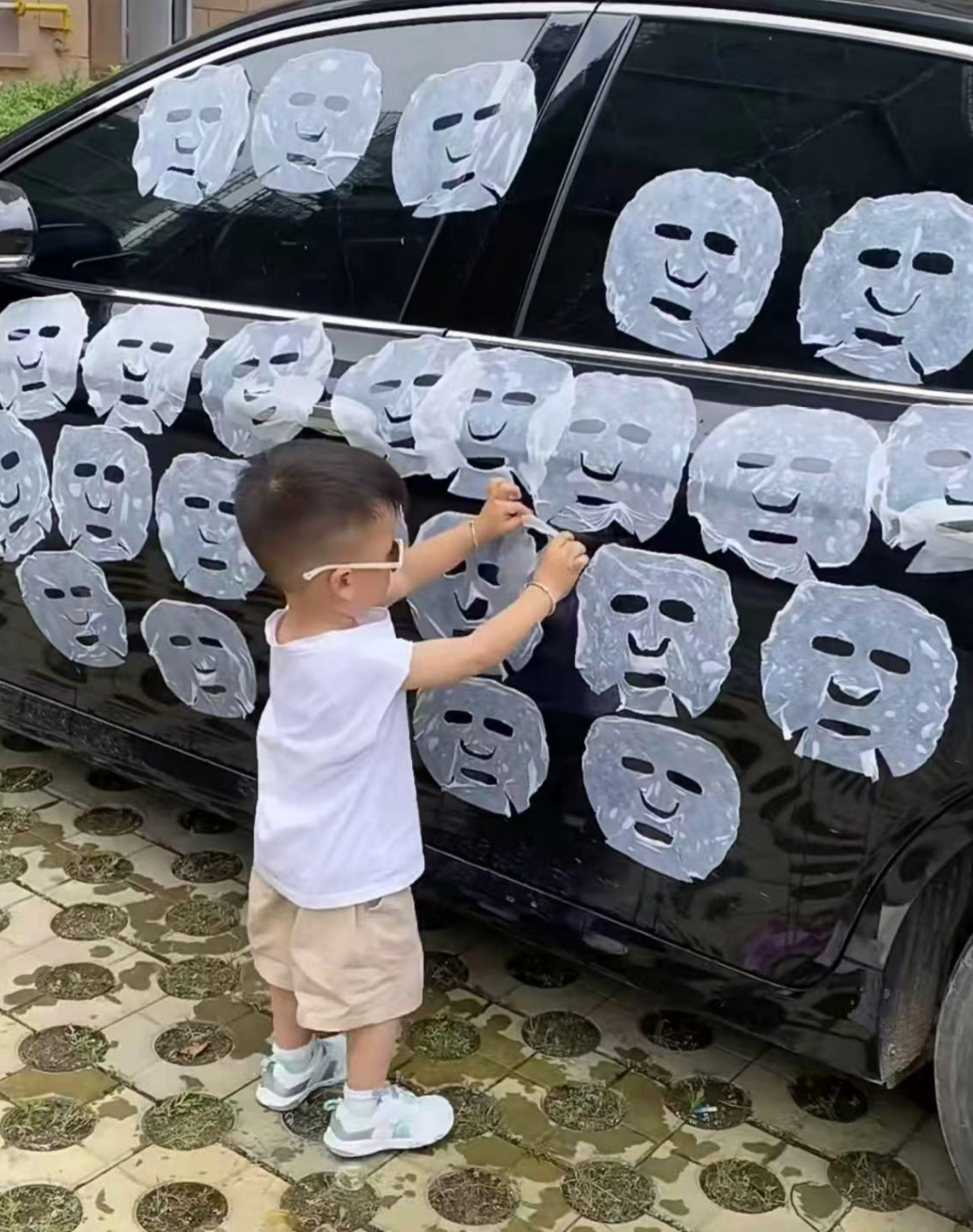 Child sticks sheet masks on car door, covering it with multiple masks