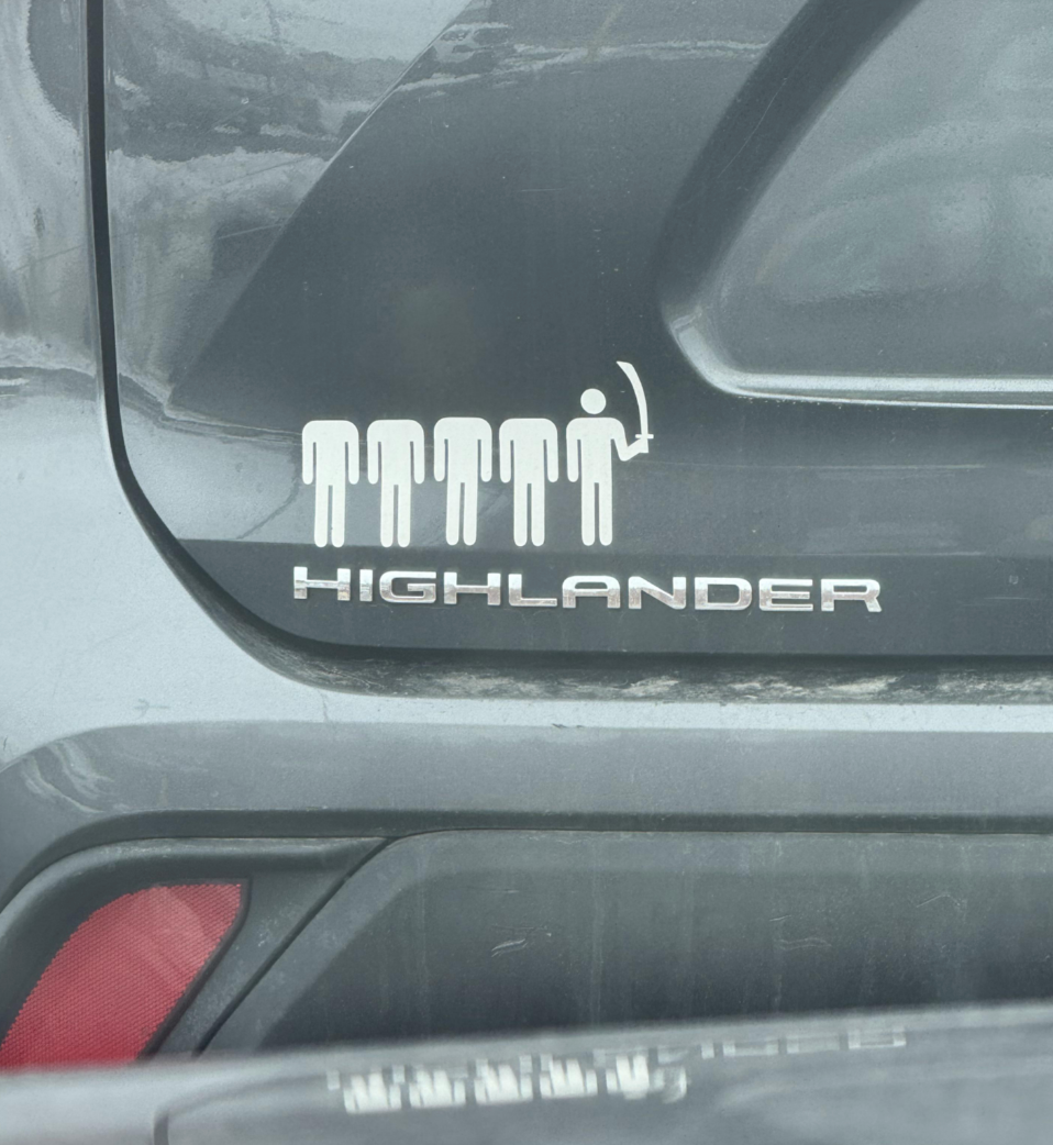 Car decal showing stick figures and one holding a sword above the word "Highlander."