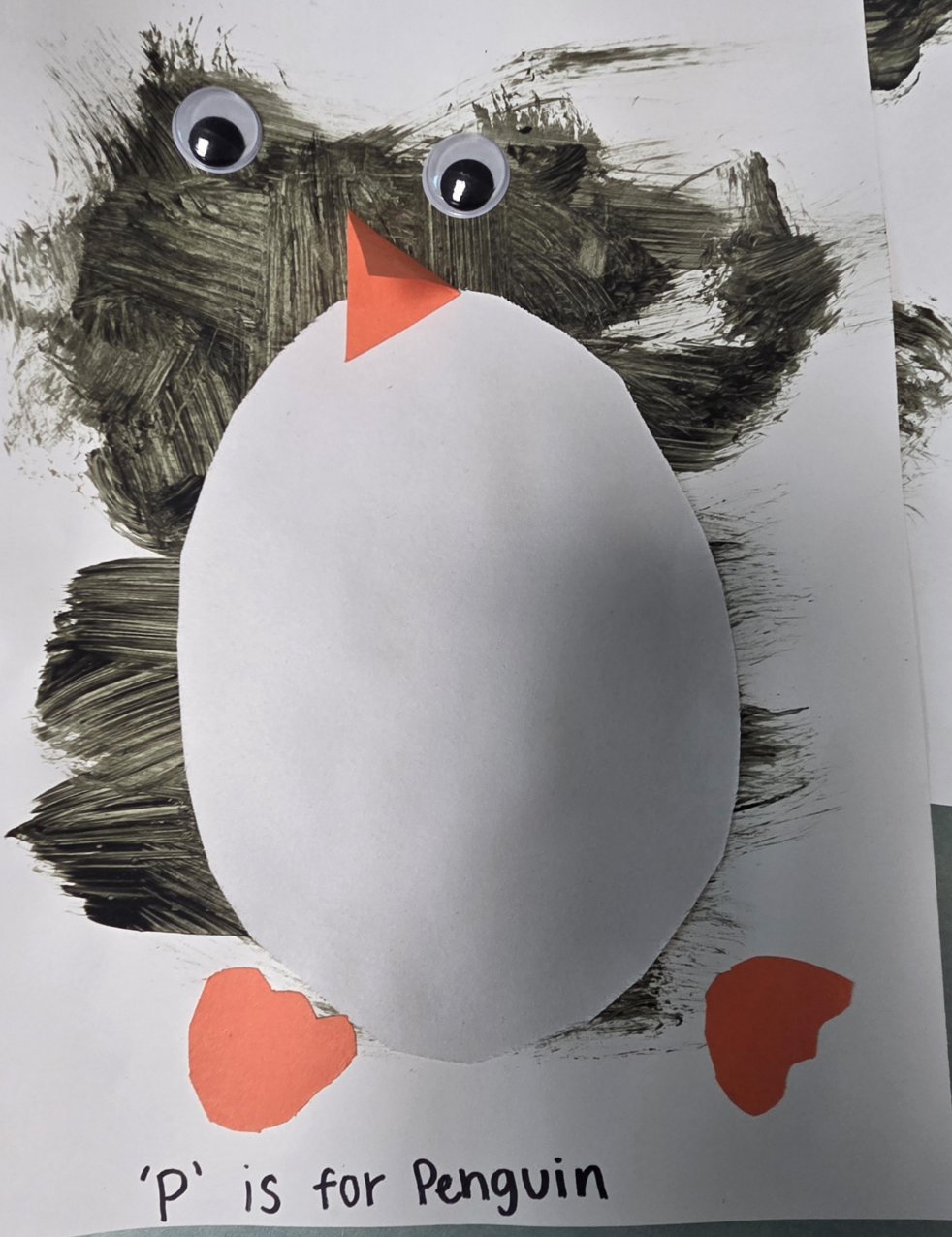 Children's penguin artwork with painted wings, googly eyes, orange beak, and feet. Text reads