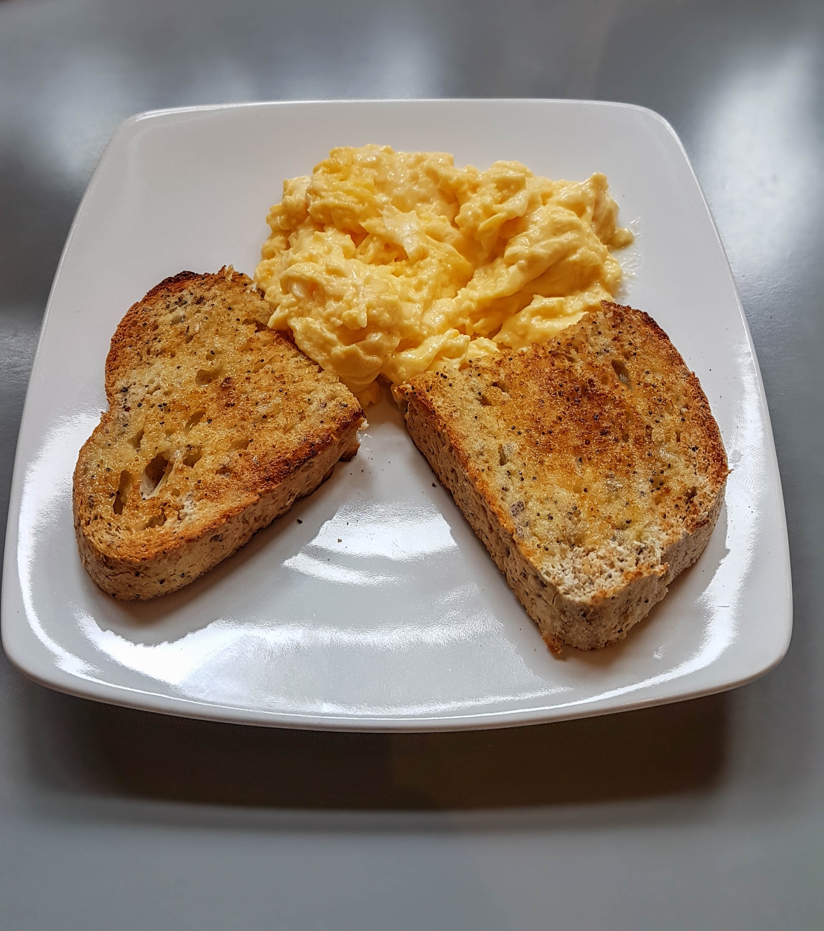 Plate with heart-shaped toast pieces and scrambled eggs