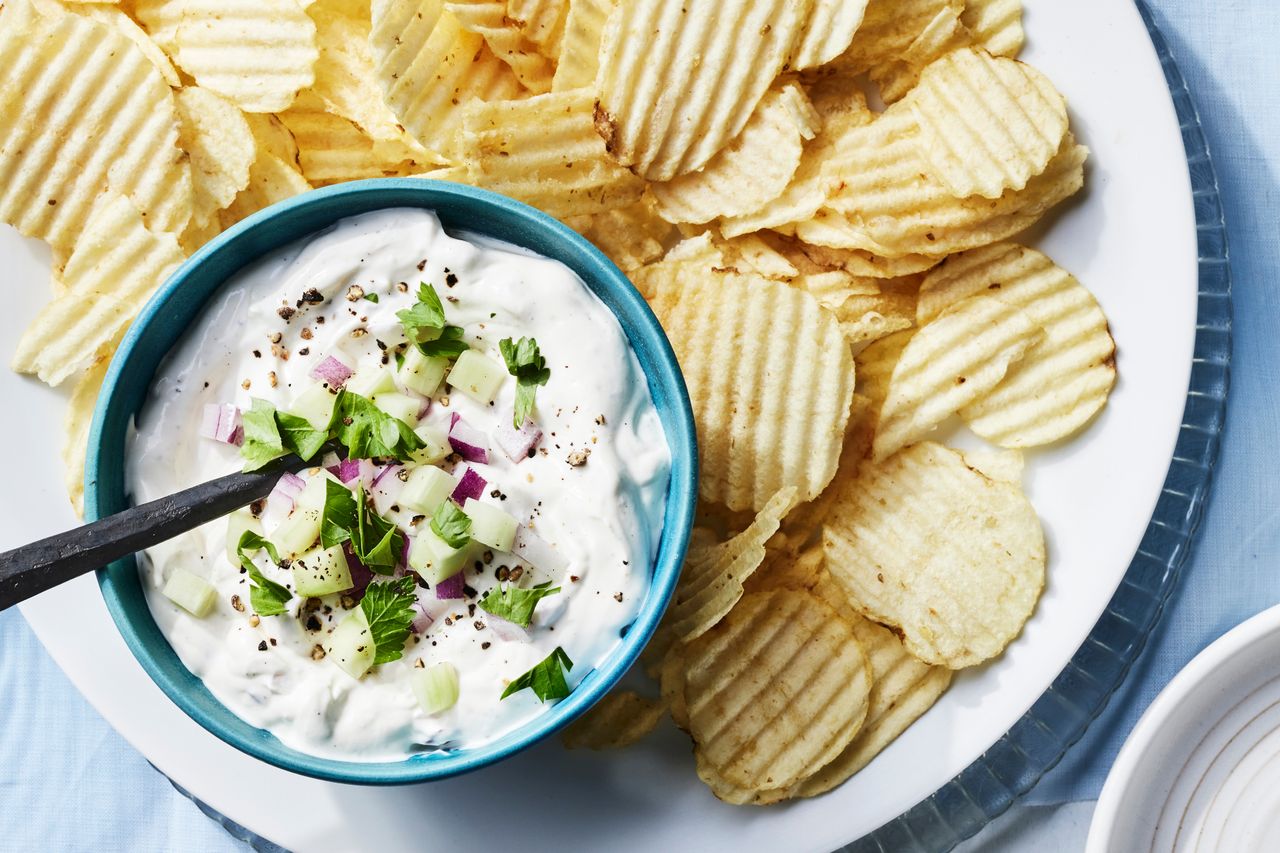 Southern Living Cucumber and Onion Dip in a blue bowl to serve with potato chips on the side