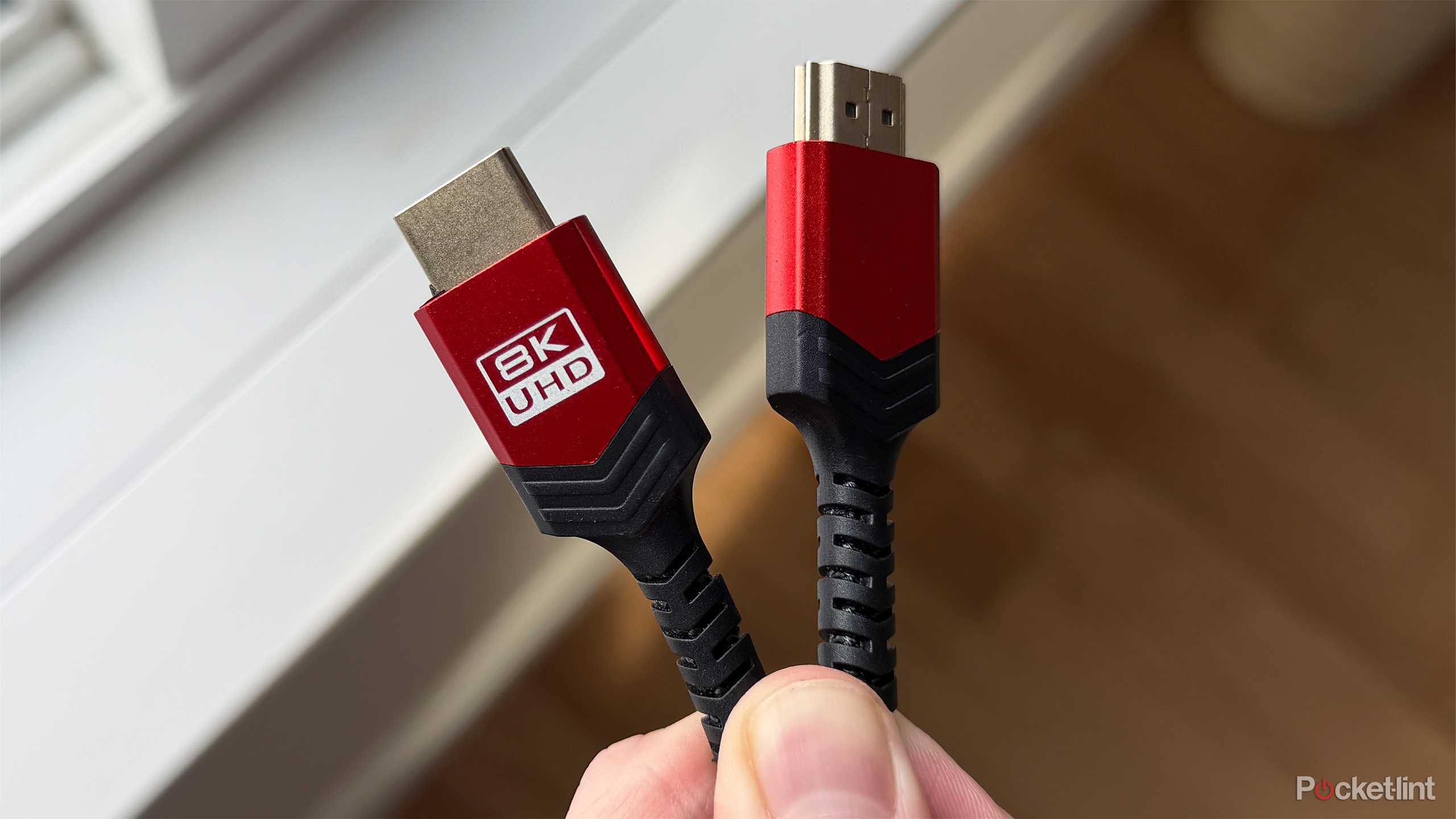 Person holding 8K HDMI cable.