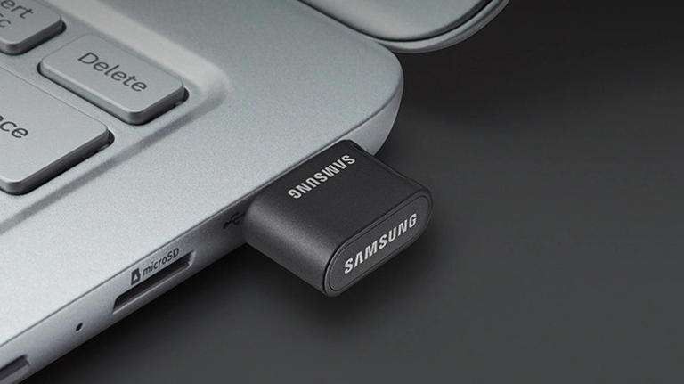 A black Samsung USB flash drive plugged into a laptop