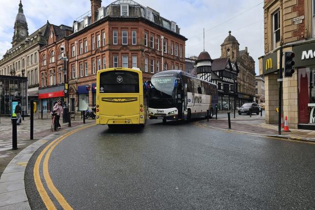 Busy town centre junction blocked after two buses get stuck on tight bend