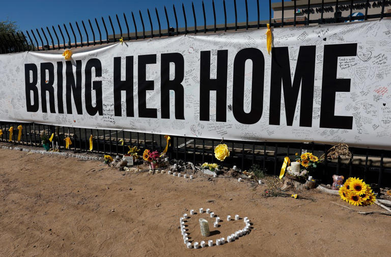 Candles and flowers are placed at a Nancy Guthrie memorial in front of the KVOA news station on March 03, 2026 in Tucson, Arizona. (Photo by Justin Sullivan/Getty Images)