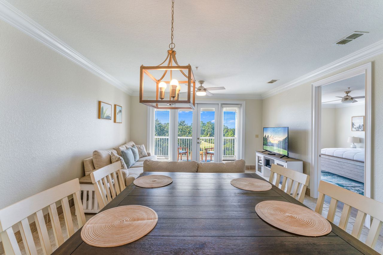 Dining area facing a living room with a view of a balcony overlooking a scenic outdoor area