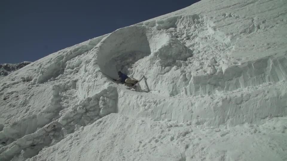 Skier falls while skiing down mountain