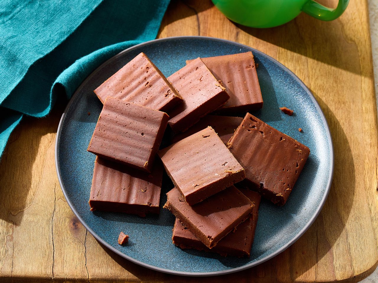 Chocolate fudge squares arranged on a blue plate.