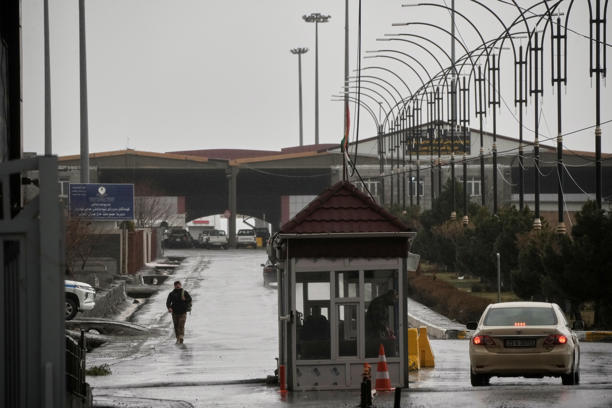 Một sĩ quan biên phòng Iraq đi về phía bên Iraq khi các xe ôtô băng qua cửa khẩu biên giới Haji Omaran ngày 15/3. Ảnh: AP