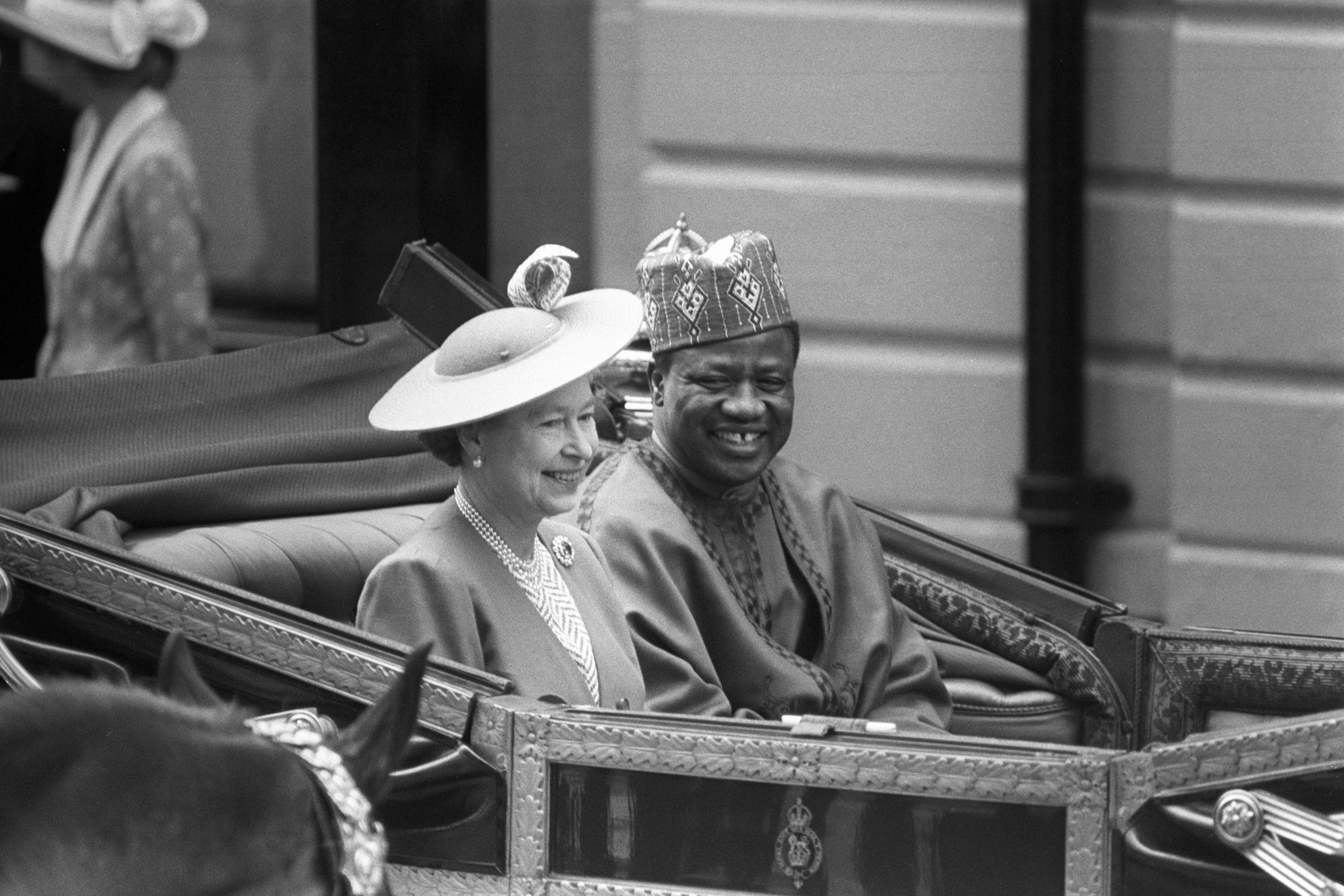 Queen Elizabeth II and Nigeria’s then-military ruler General Ibrahim Babangida, travelling by carriage from Victoria Station to Buckingham Palace in 1989 (David Giles/PA) (PA Archive)
