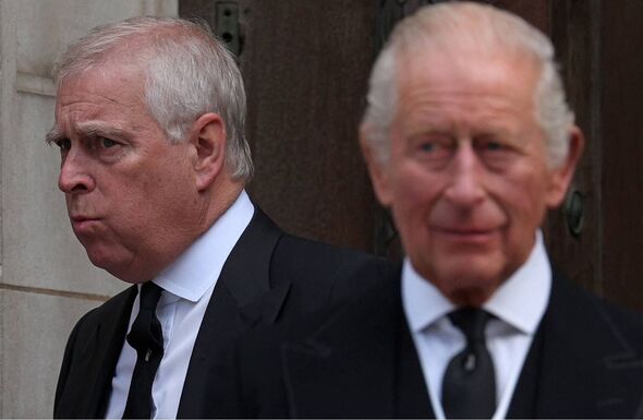 Two elderly men dressed in formal attire are standing next to each other outside a building, appearing to engage in conversation