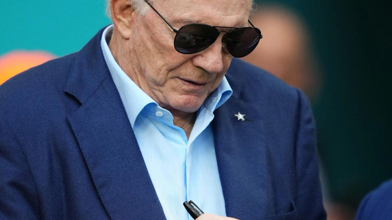 Dec 24, 2023; Miami Gardens, Florida, USA; Dallas Cowboys owner Jerry Jones signs a helmet prior to the game against the Miami Dolphins at Hard Rock Stadium. Mandatory Credit: Jasen Vinlove-USA TODAY Sports