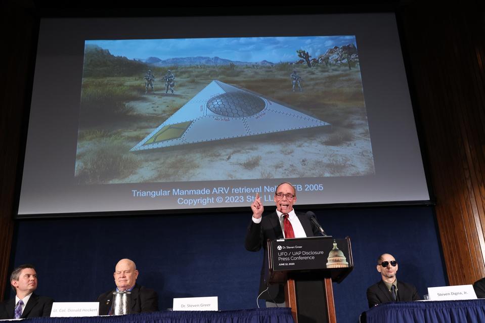 Steven Greer, ufologist and founded of the Center for the Study of Extraterrestrial Intelligence and the Disclosure Project, delivers remarks on his UFO and Unidentified Aerial Phenomena (UAP) research under an artist rendering of an incident, during a press conference on June 12, 2023. Photo by Kevin Dietsch/Getty Images