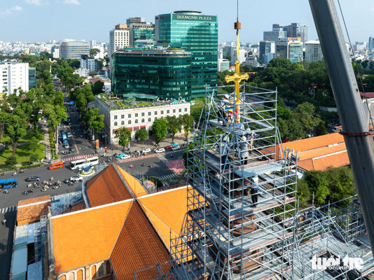 Thánh giá thứ nhất được đưa lên đỉnh tháp kẽm nhà thờ - Ảnh: VĂN TRUNG