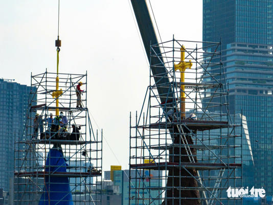 Hai cây thánh giá mạ vàng sau khi được đặt lên đỉnh tháp kẽm - Ảnh: VĂN TRUNG