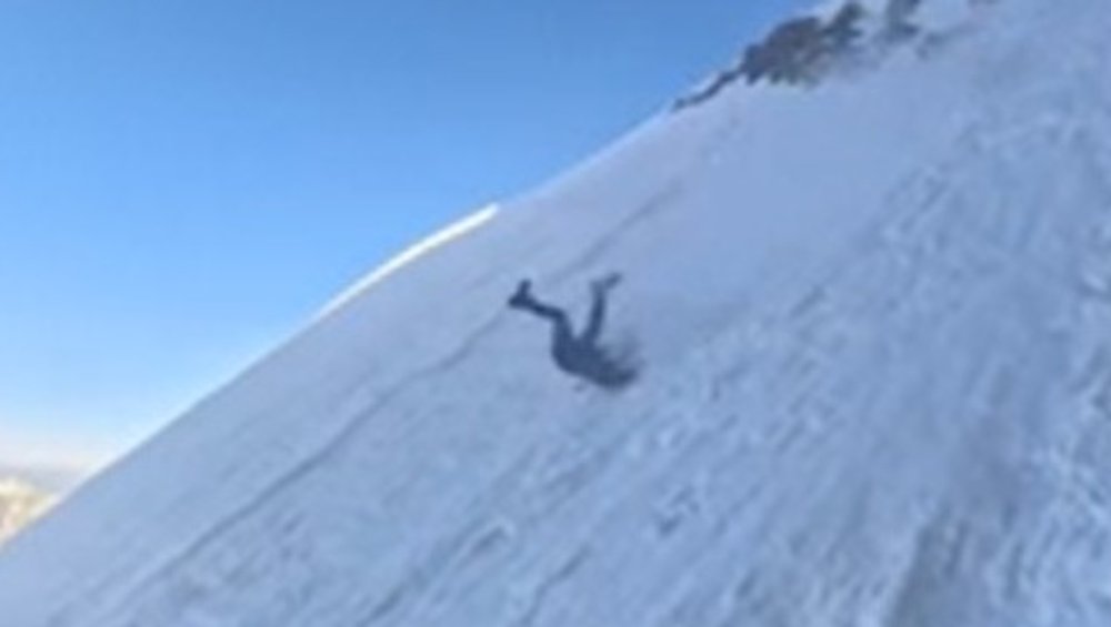 Mountaineer slides down slope and rolls over several times