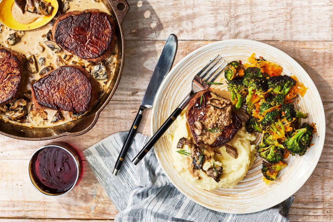 Southern Living Smothered Steaks With Mushroom Sauce served over mashed potatoes with roasted cheddar broccoli
