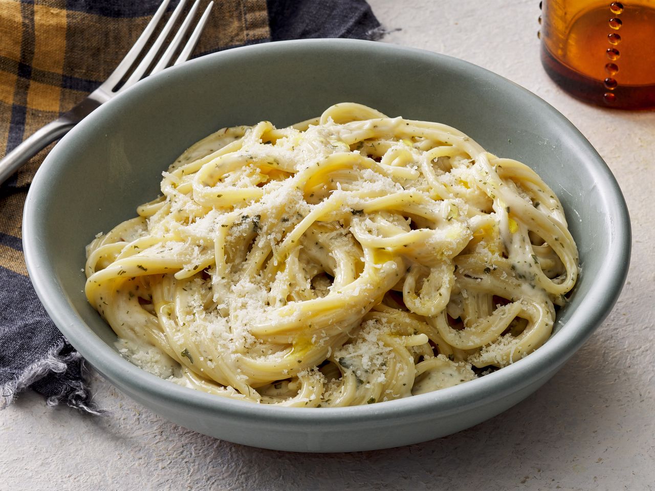 A bowl of creamy garlic pasta, topped with parmesan cheese