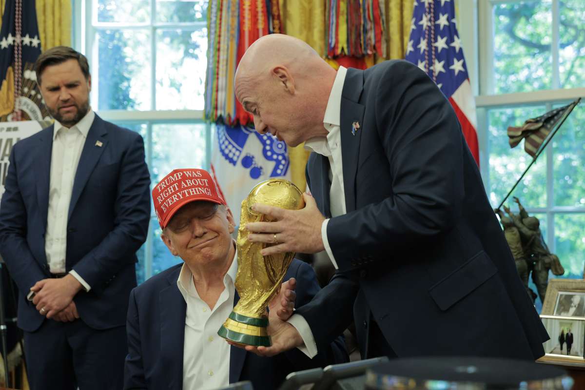 FIFA President Gianni Infantino shows U.S. President Donald Trump the World Cup Trophy in the Oval Office as Vice President JD Vance looks on August 22, 2025 in Washington, DC. Trump announced the FIFA World Cup 2026 draw will take place at The Kennedy Center. (Photo by Chip Somodevilla/Getty Images)