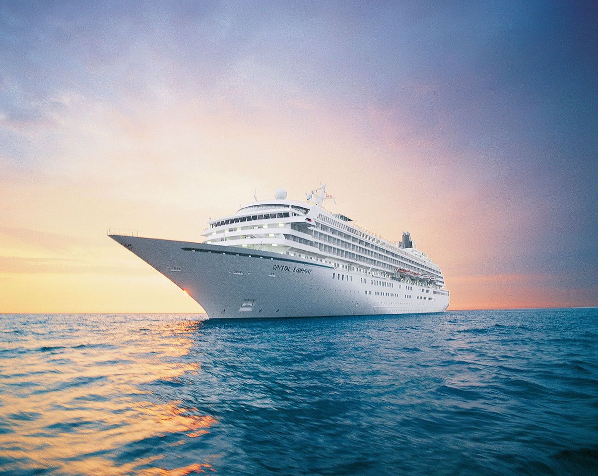 A large cruise ship on the ocean during sunset