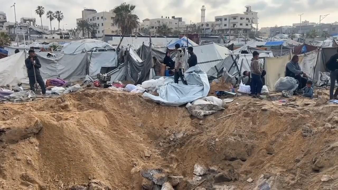 Displaced Palestinians in Gaza return to a tent camp that was struck by ...