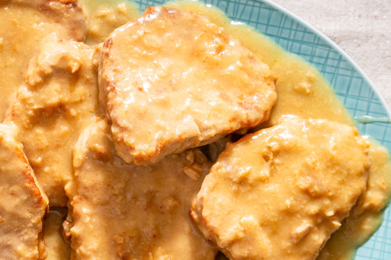 Plated cooked pork chops covered in a creamy sauce