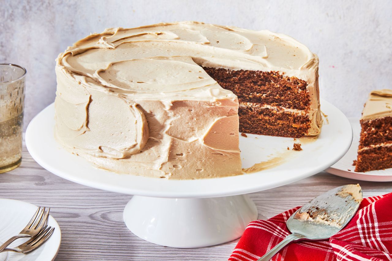 Southern Living Coca Cola Cake on a cake plate with a slice taken out