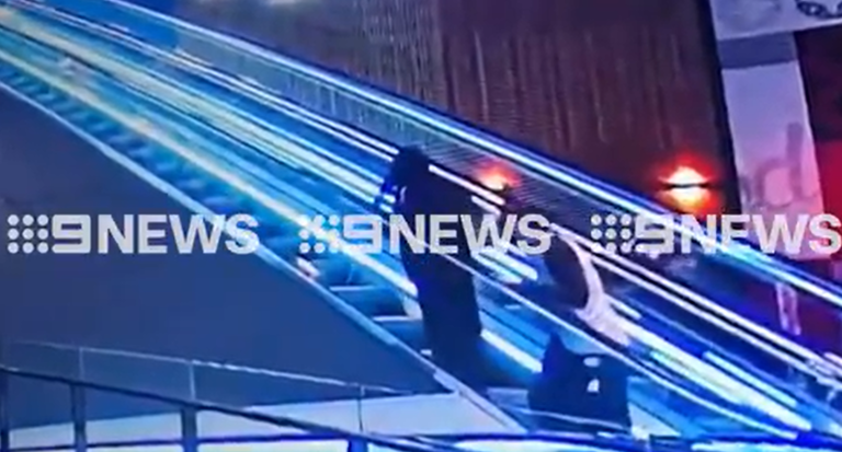 Standing behind her, the male allegedly pulls a knife from his pocket and stabs the woman in the back.