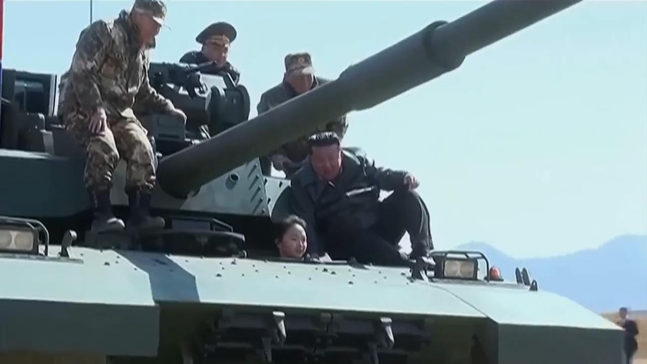North Korean leader sits on tank with his daughter at military exercise