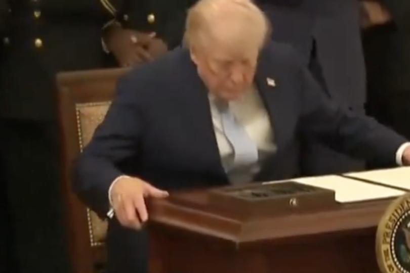 Grimacing Trump struggles to sit down in chair with leg bending in ...