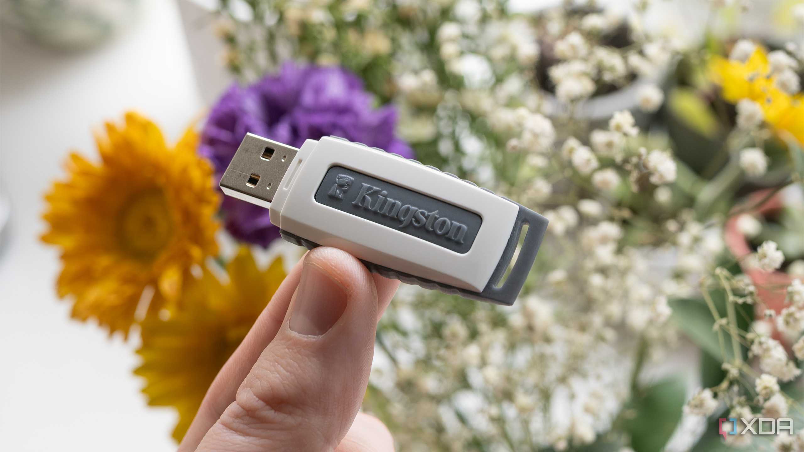 A USB Stick held in front of flowers