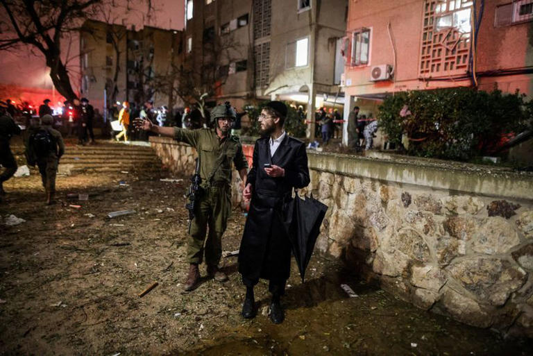 An Israeli soldier secures the impact site after Iranian missile barrages struck residential buildings in Arad, amid the U.S.-Israel conflict with Iran, in southern Israel March 22, 2026. REUTERS/Ilan Assayag