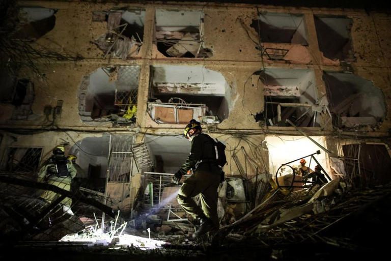 An Israeli soldier uses a torch to inspect the damage after Iranian missile barrages struck Dimona, amid the U.S.-Israel conflict with Iran, in southern Israel March 21, 2026. REUTERS/Ilan Assayag