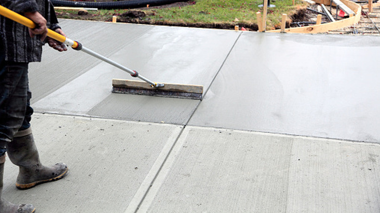 Man smoothing a freshly poured concrete driveway
