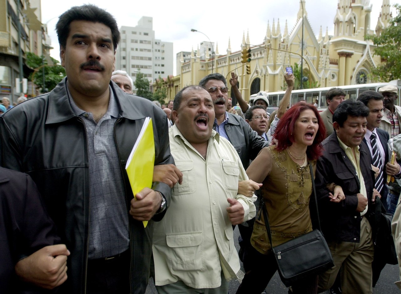 Lawmakers Nicolás Maduro, Francisco Solorzano and Cilia Flores lock arms outside the National Congress building in 2003.