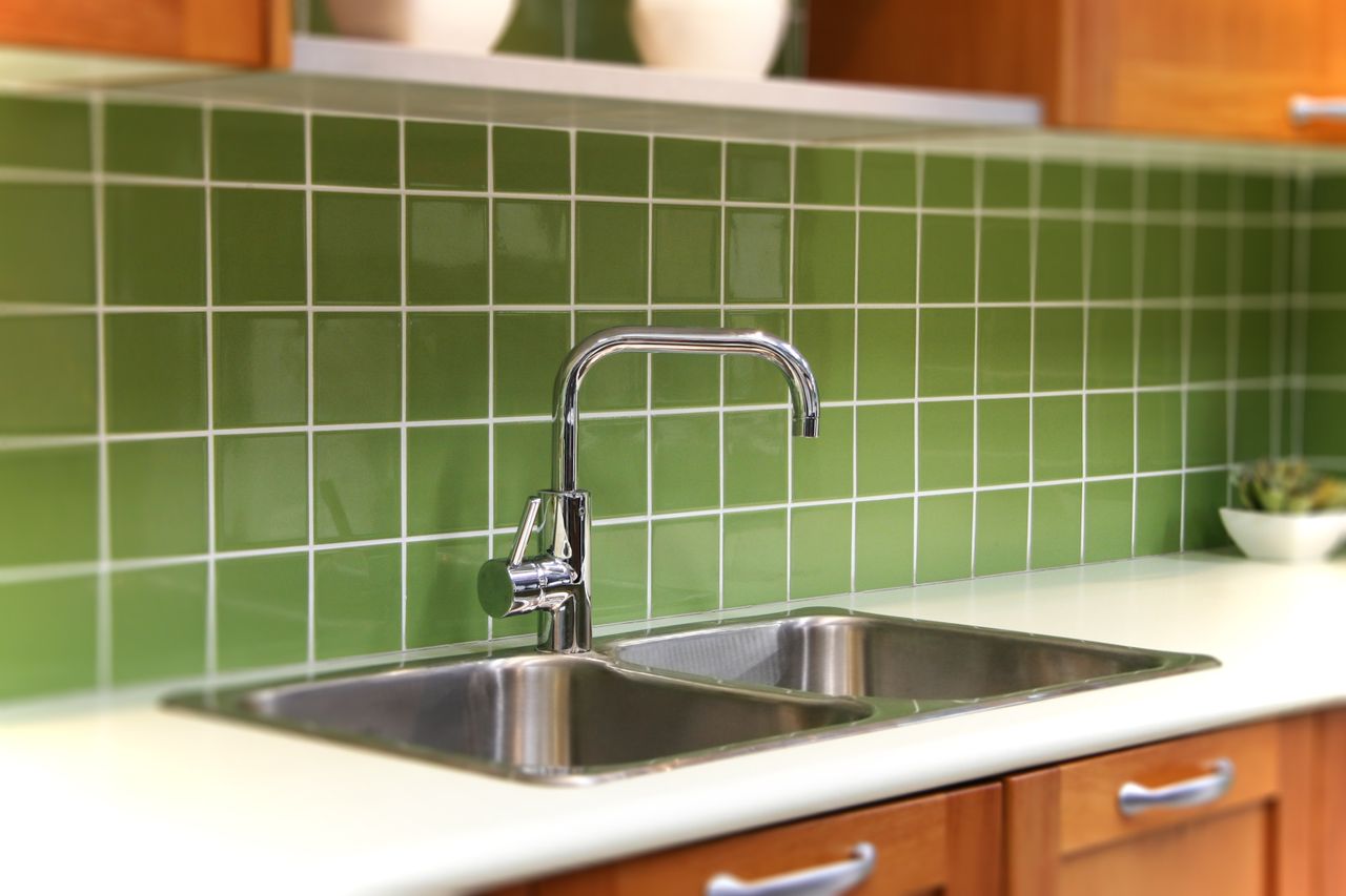 Kitchen with avocado green backsplash.
