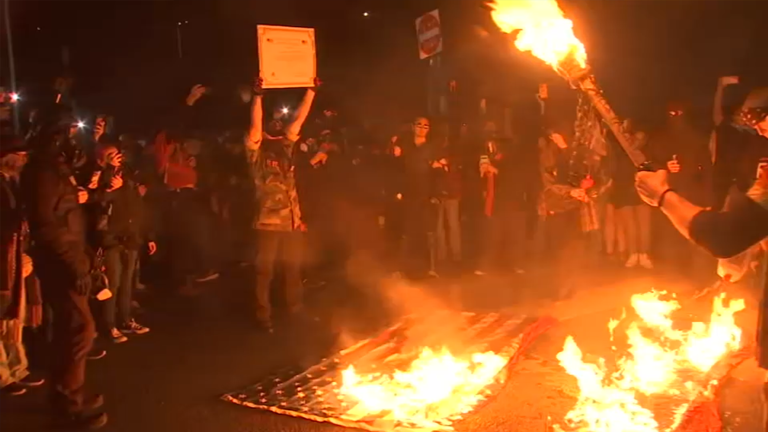 Protesters break through gates at Portland ICE facility, burn flags on ...