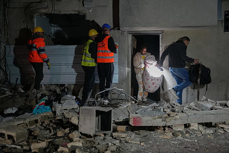 Los residentes llevan pertenencias personales a medida que salen de un edificio dañado en un ataque con misiles en Tel Aviv, Israel, la madrugada del sábado 28 de marzo de 2026 Maya Levin/Copyright 2026 The AP. All rights reserved