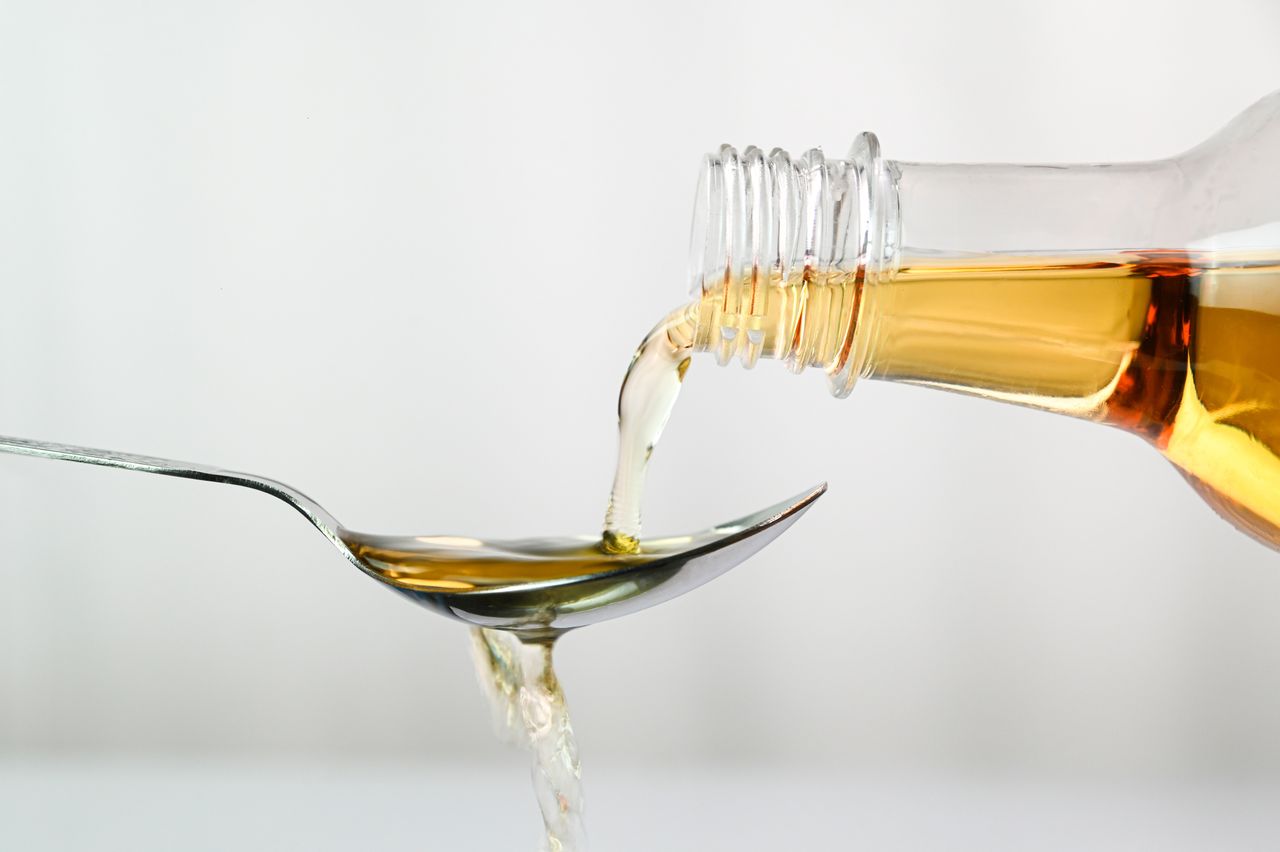 Apple cider vinegar being poured onto a spoon