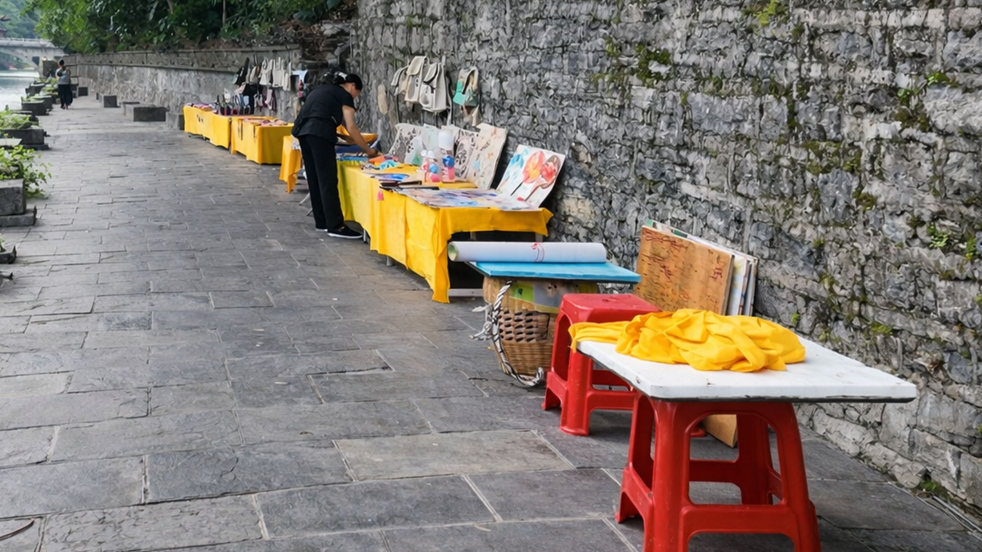 Vendors set up small displays along a riverside path in China