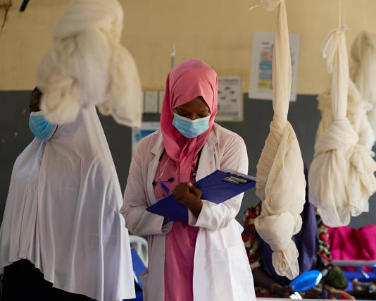 A supervising doctor updates records at the Alima medical facility in Kaita. Photograph: Terna Iwar/The Guardian