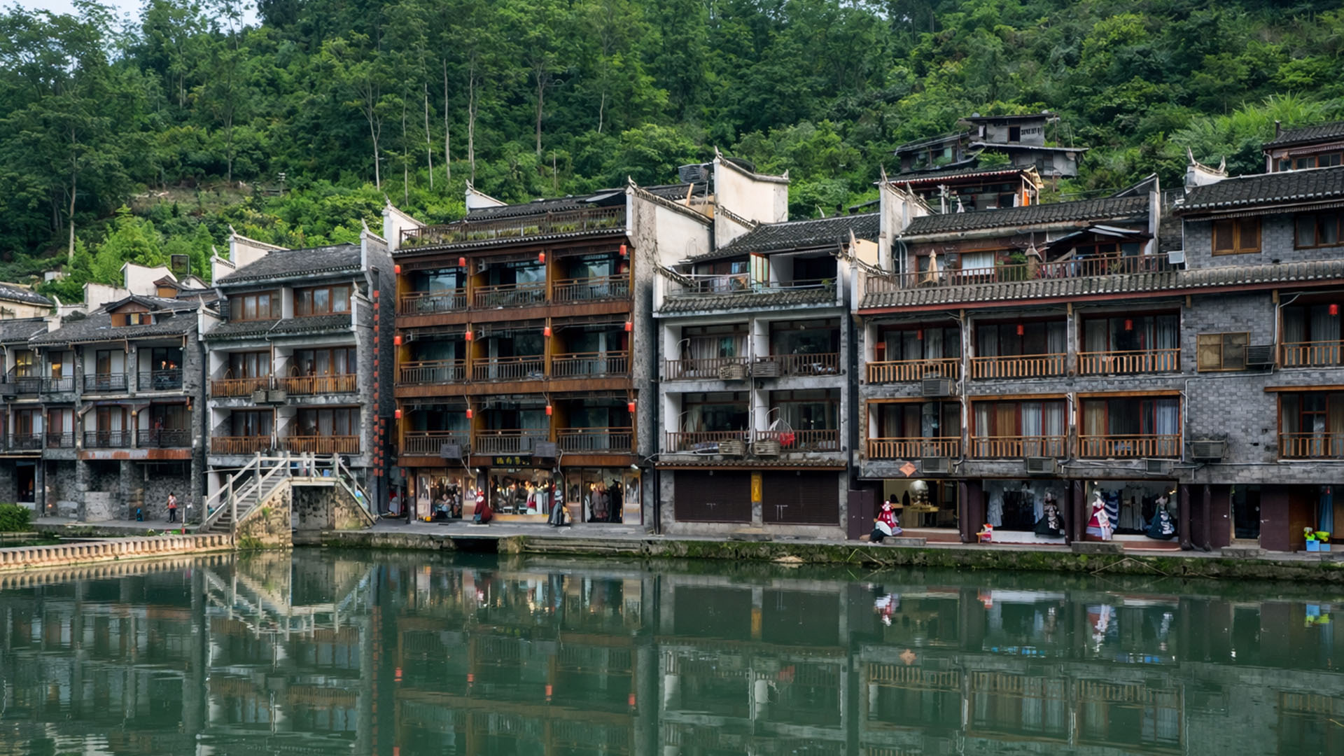 Een rij traditionele huizen langs een rustige rivier in China