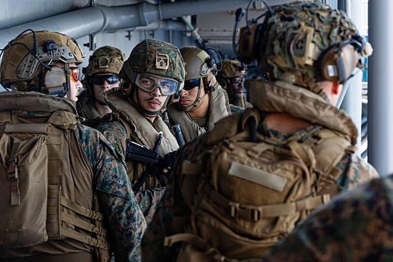 Marineros e infantes de marina estadounidenses a bordo del USS Tripoli (LHA 7) llegando a la zona de responsabilidad del Mando Central de Estados Unidos, 27 de marzo de 2026. U.S. Central Command via AP