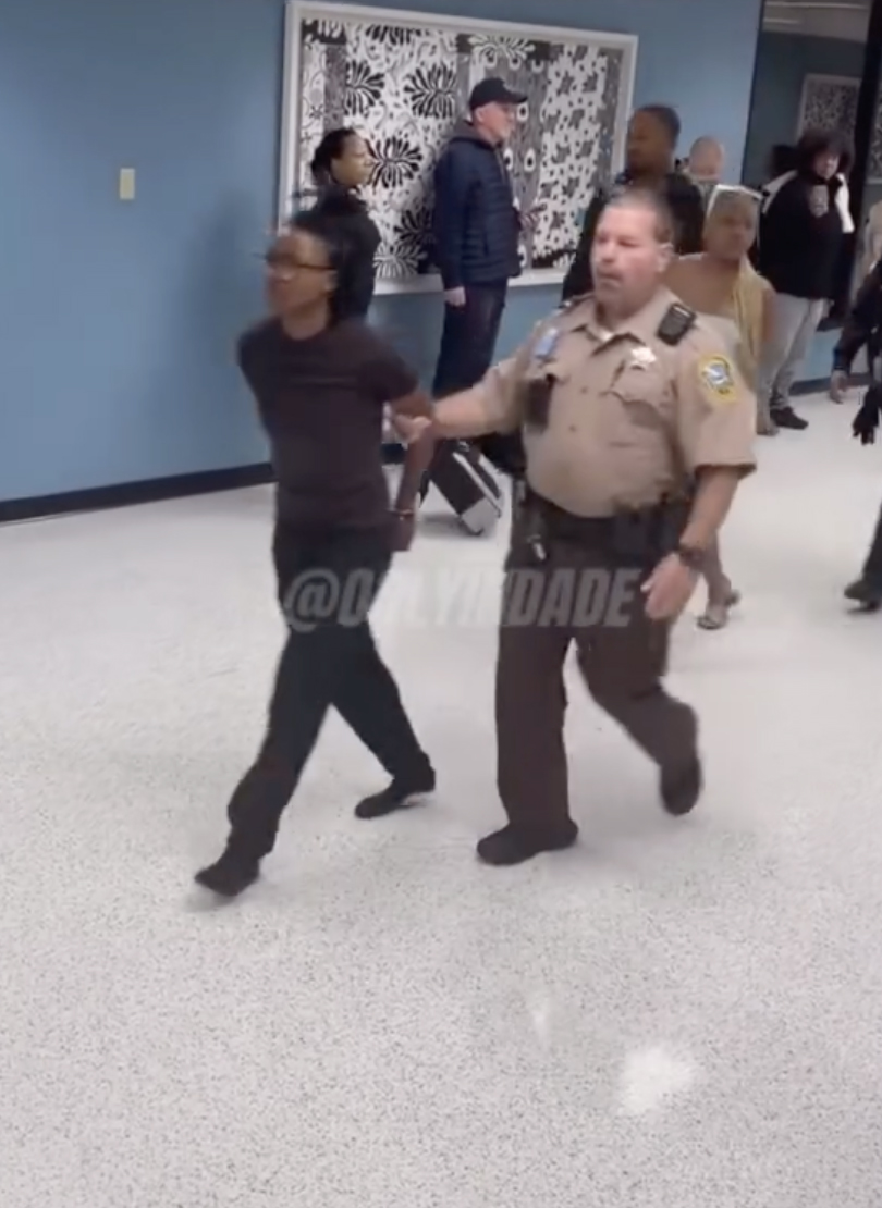 Dionjana Cochran is escorted in the Miami terminal. onlyindade/instagram