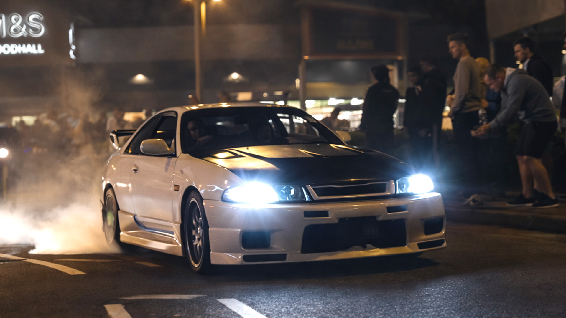 Nissan Skyline R33 shows raw street energy under the city lights
