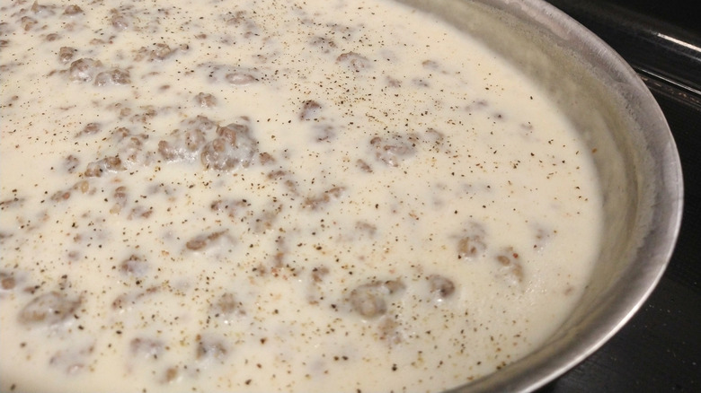Pan of sausage gravy with black pepper flakes