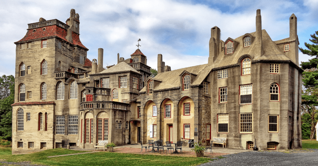 The sprawling, eclectic concrete exterior of Fonthill Castle in Doylestown, Pennsylvania, under a cloudy sky.